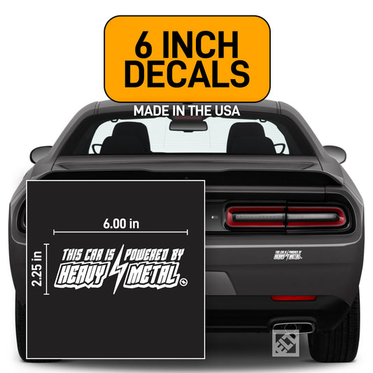 White 6 inch "This Car is Powered by Heavy Metal" vinyl decal on a dark gray Dodge Challenger.